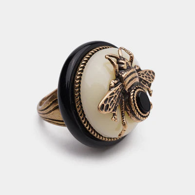 Bague "Reine Noire" en laiton doré ornée d'une abeille en métal avec une petite pierre noire sur un fond blanc