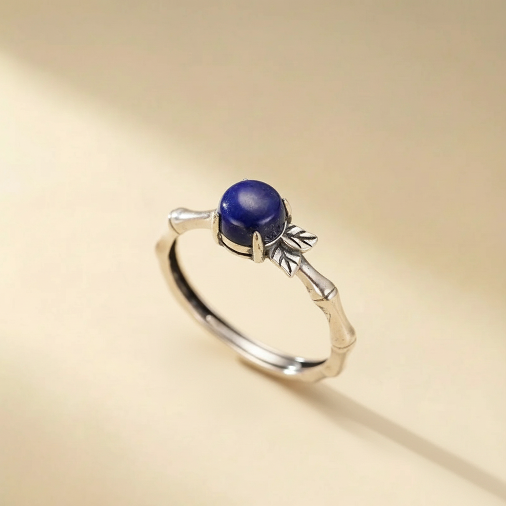 Bague en argent 925 avec une pierre de lapis-lazuli bleu profond, design inspiré des tiges de bambou et feuilles.