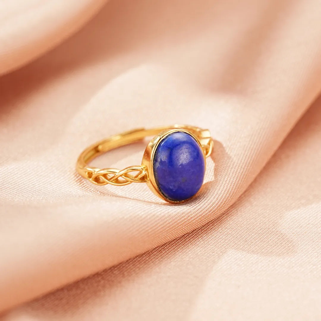 Bague en argent doré or 18 carats avec une pierre de lapis-lazuli ovale et un design tressé sur l'anneau.