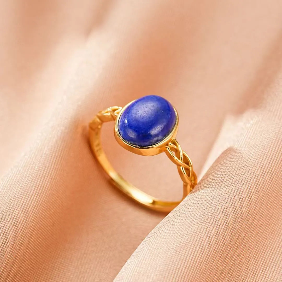 Bague en argent doré or 18 carats sertie d'une pierre de lapis-lazuli ovale, design tressé élégant.