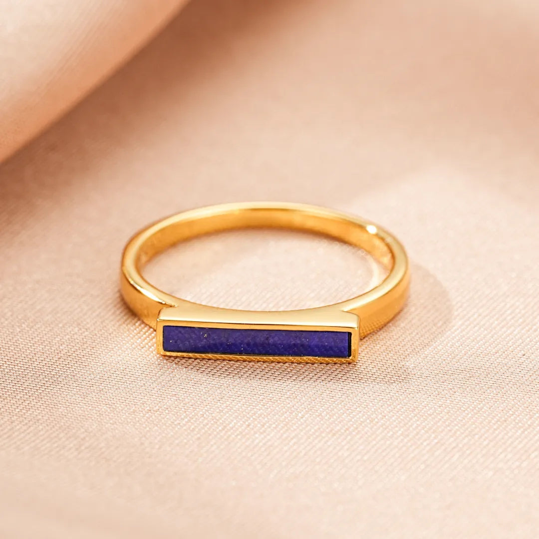 Bague fine en argent doré à l'or, sertie d'une barre de lapis lazuli bleu profond. Le design épuré met en valeur la pierre naturelle.