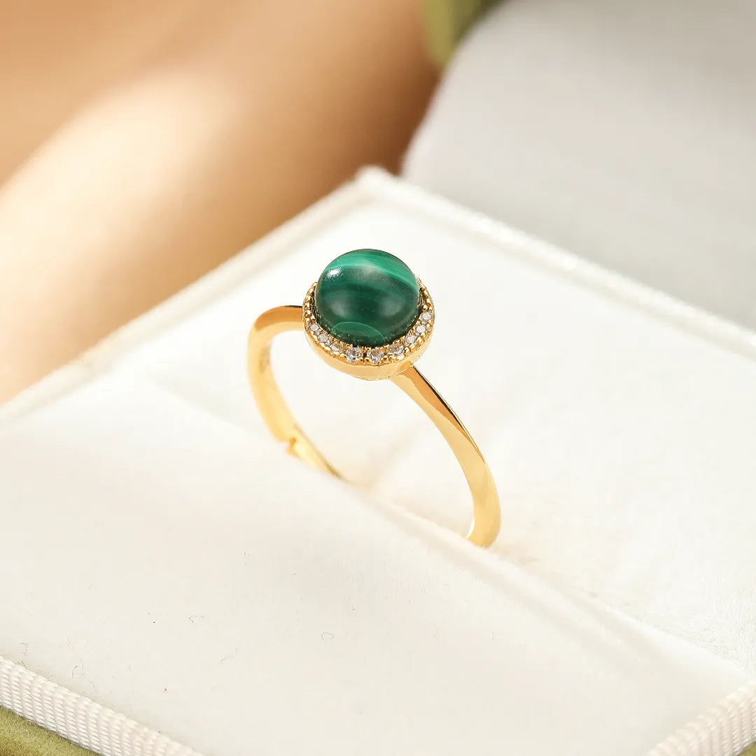 Bague en argent doré sertie d'une malachite ronde et d'un halo de zirconiums scintillants.