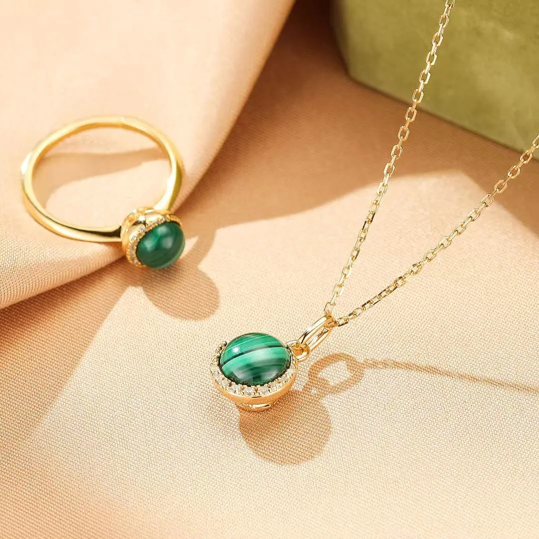 Ensemble de bijoux "Halo Éclatant" en argent doré or, comprenant une bague et un pendentif avec une pierre de malachite verte et des zircons scintillants.