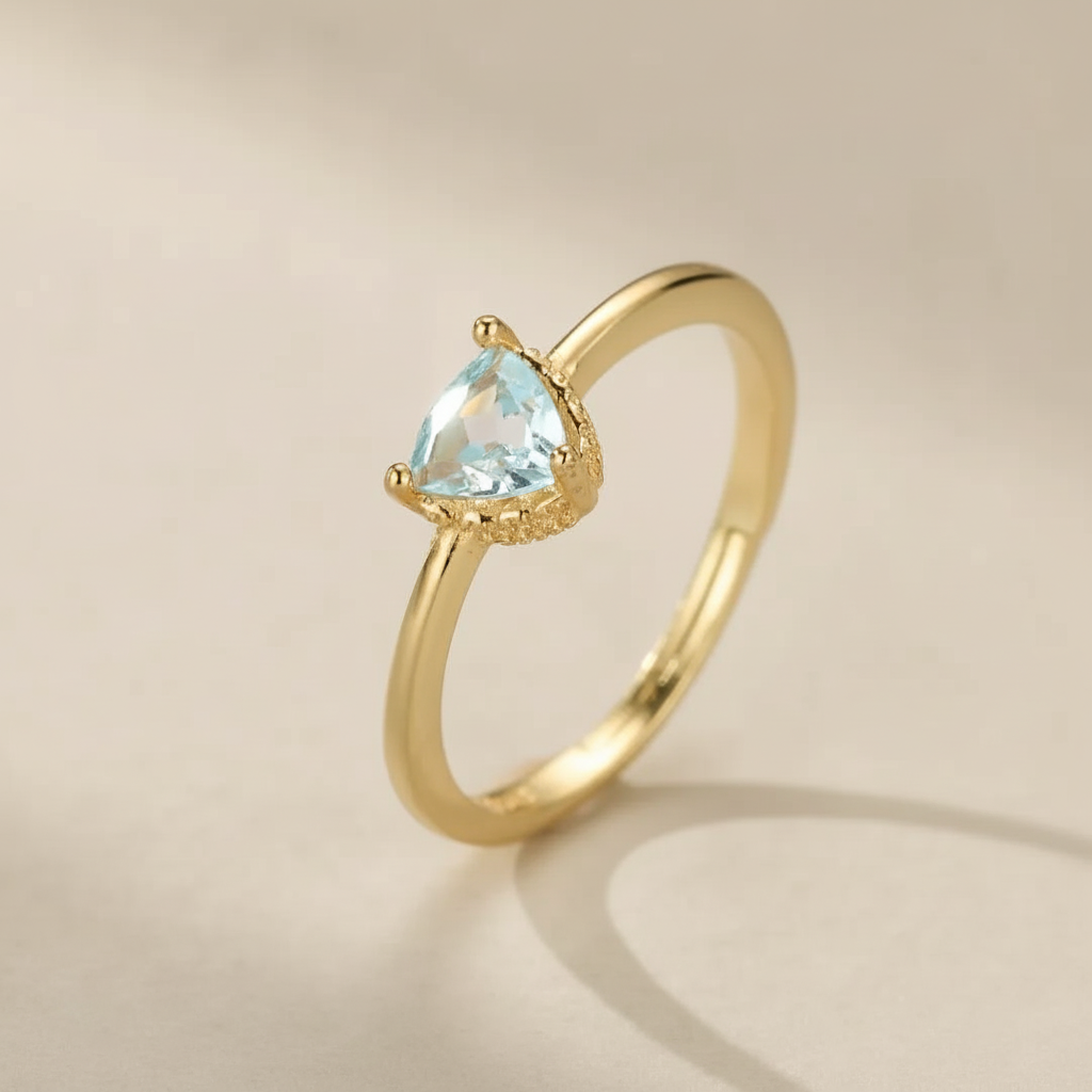 Bague fine en argent doré à l'or 18 carats sertie d'une topaze bleue en forme de triangle taillée en facettes, nom "Clarté Céleste".