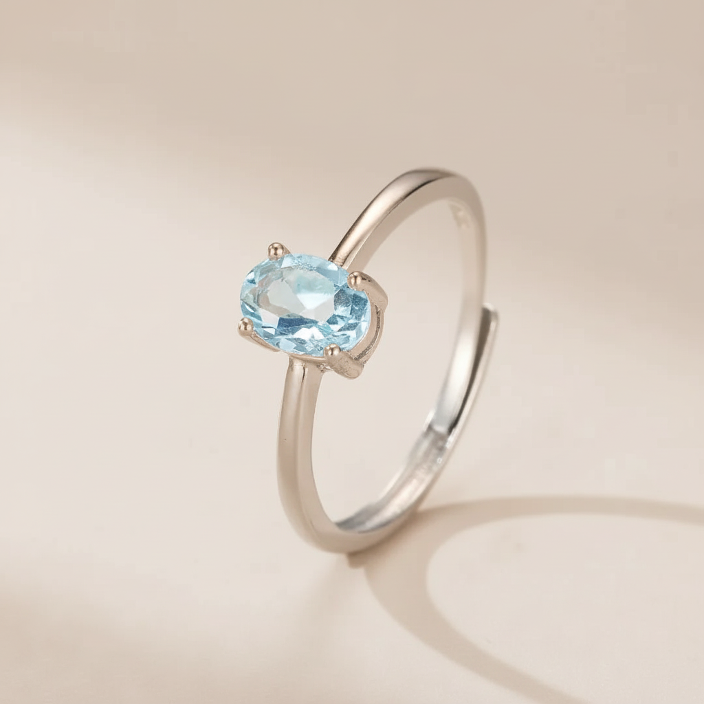 Bague ajustable en argent 925 avec une topaze bleue ovale sertie sur un fond neutre.