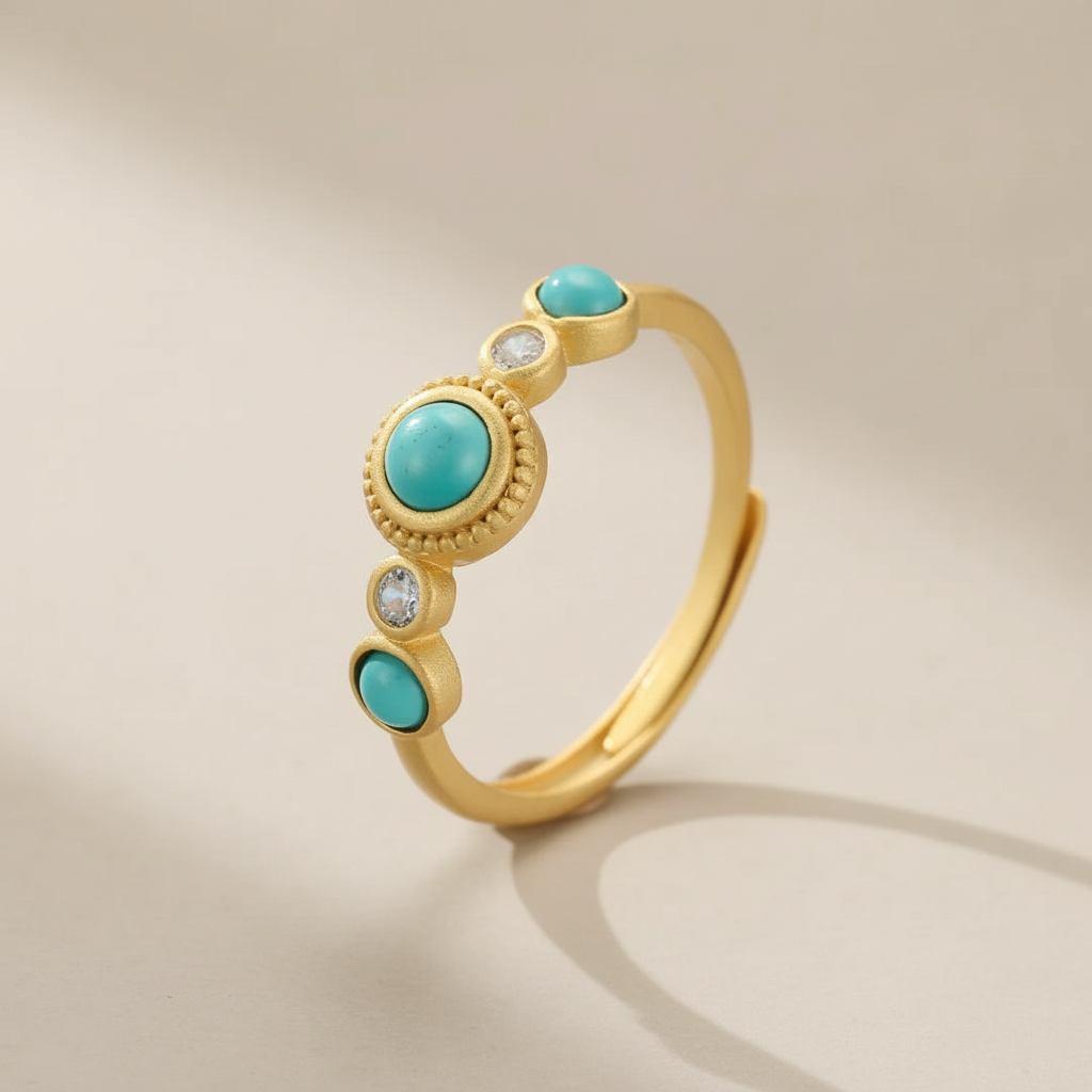 Bague en argent plaqué or ornée de turquoises rondes et de petites pierres blanches, design inspiré du désert.