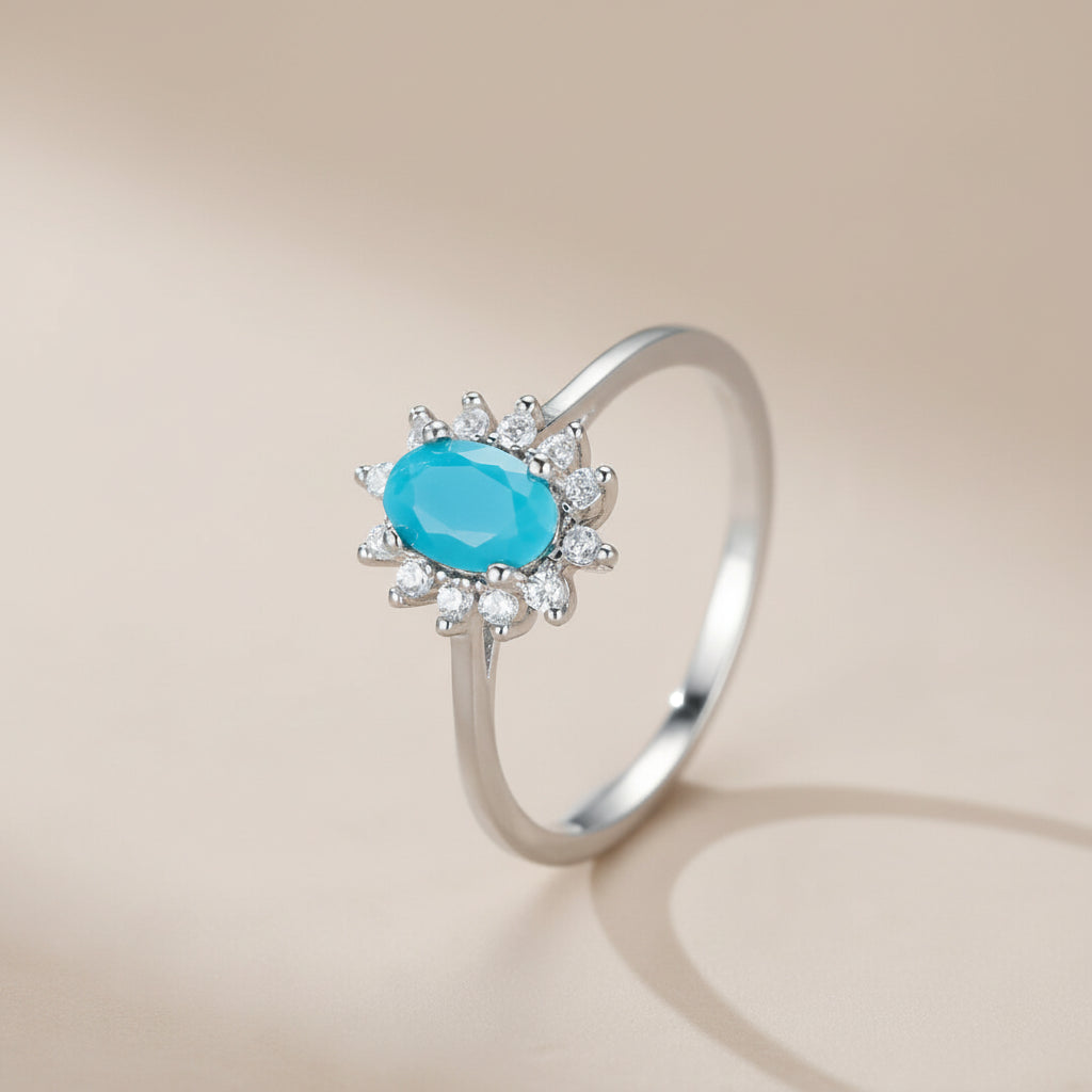 Bague en argent 925 avec une turquoise ovale bleue et une aura de petits zircons blancs, style fleur marine.