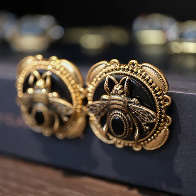 Boucles d'oreilles plaquées or avec motif abeille ornée d'une pierre d'agate noire centrale, style vintage.
