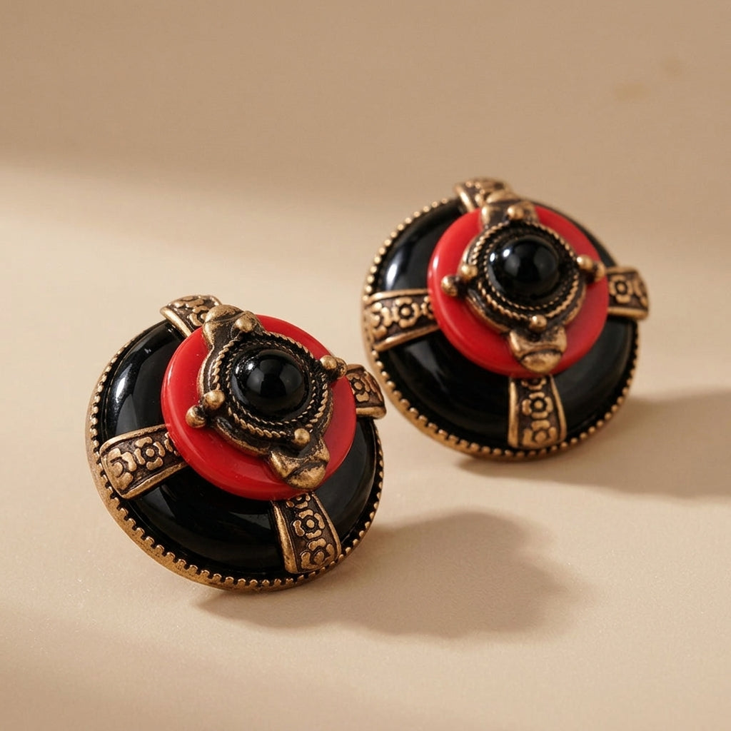 Boucles d'oreilles rondes avec une pierre noire au centre, ornées de détails dorés et d'un cercle rouge, évoquant un style vintage. @main