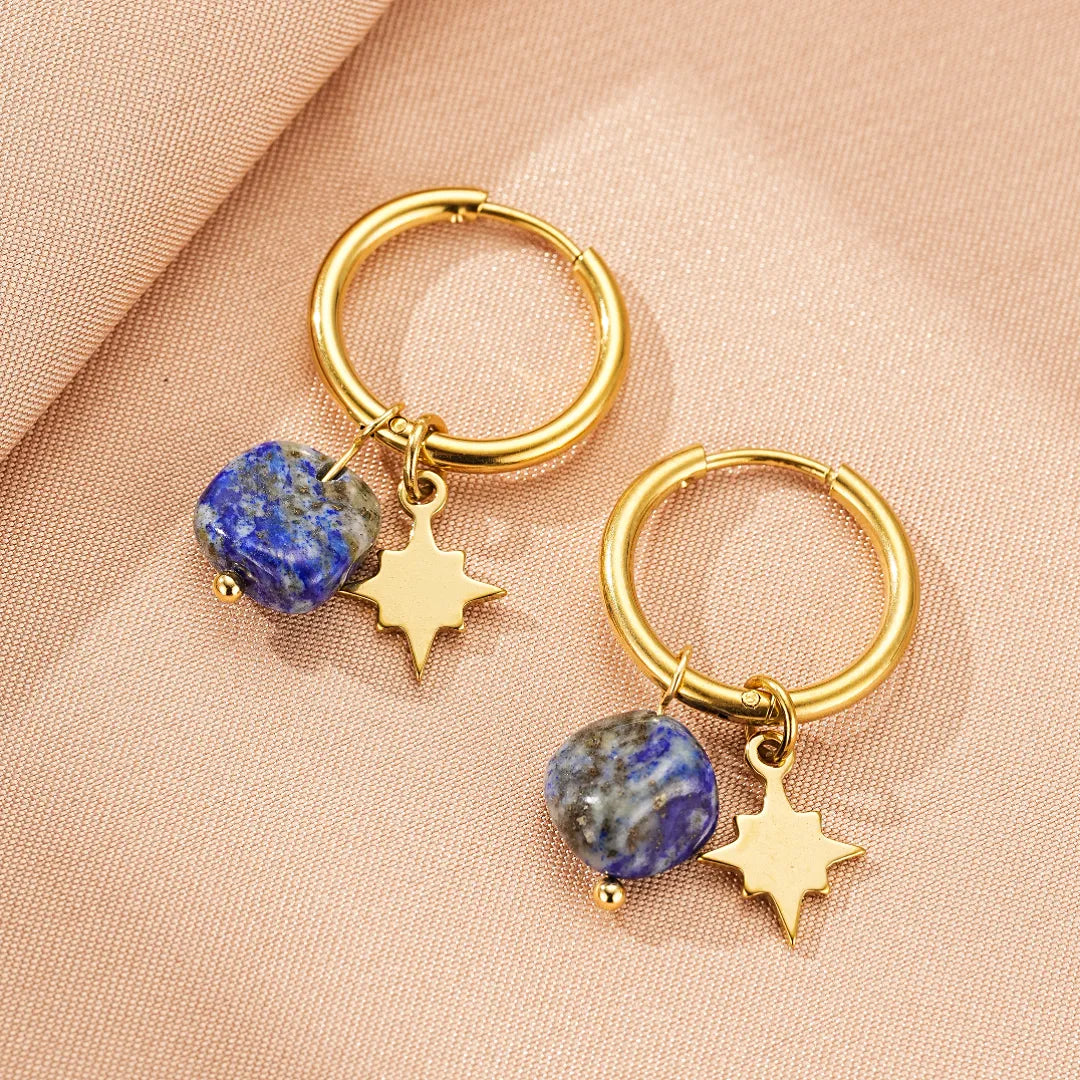 Boucles d'oreilles créoles dorées ornées d'une petite étoile dorée et d'une pierre bleue brute en lapis lazuli.