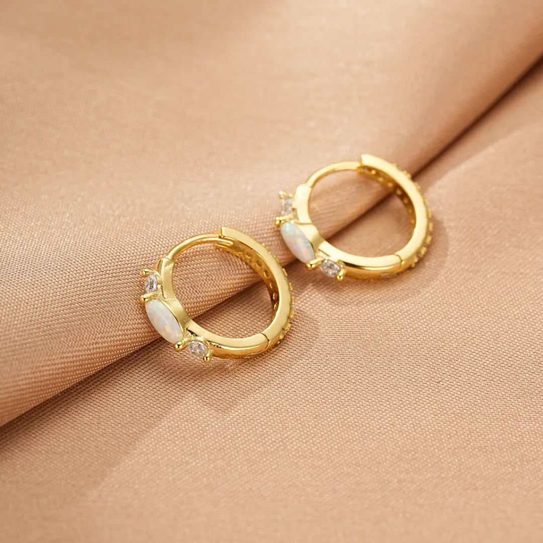 Paire de boucles d'oreilles créoles en argent doré ornées d'opales et de zirconiums brillants, sublimant le cou de leur éclat nacré.