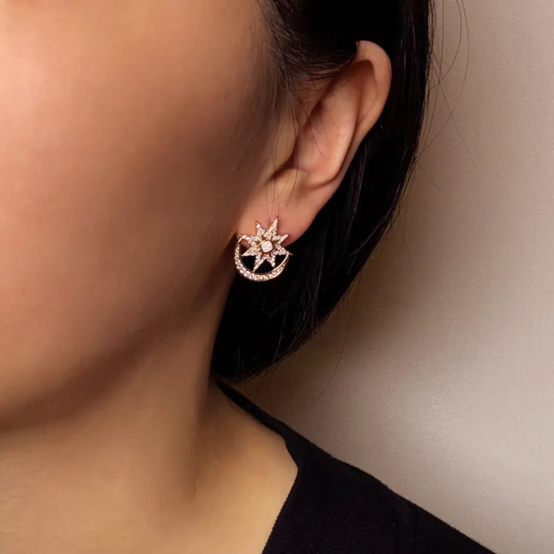 Boucles d'oreilles en forme de croissant de lune et d'étoile ornées d'opale et de diamants scintillants, portées par une femme.