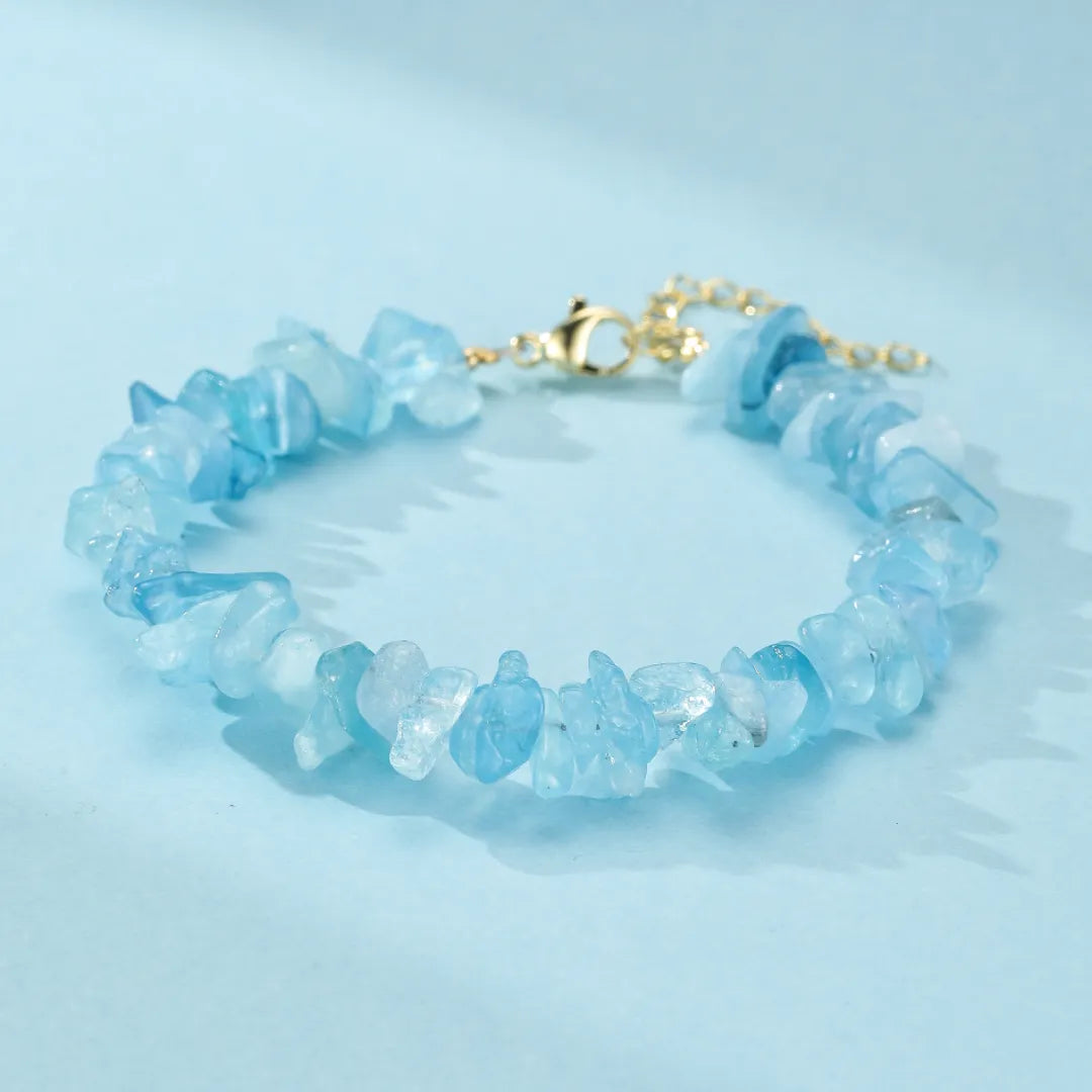 Bracelet "Trésor Marin" fait de pierres d'aigue-marine naturelles et d'une chaîne dorée réglable.
