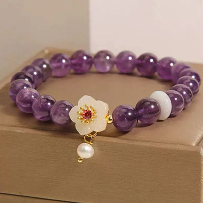 Bracelet "Fleur d'Harmonie" en améthyste, jade blanc et perle, orné d'un pendentif fleur blanche avec cœur rouge et perle nacrée tombante.