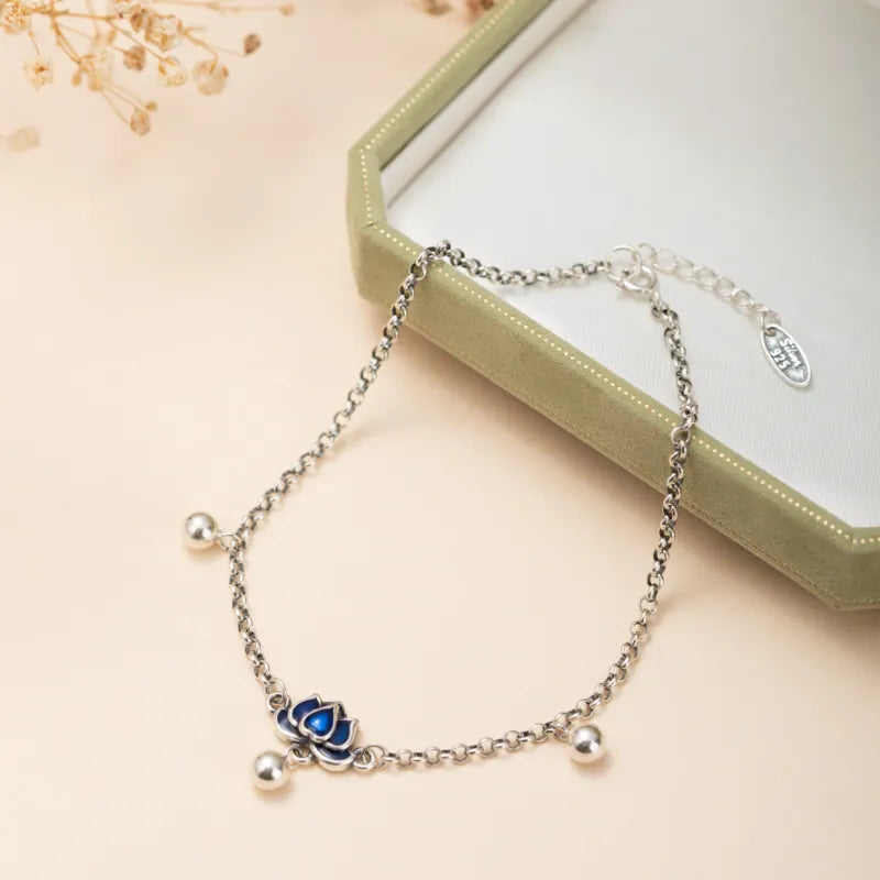 Bracelet de cheville en argent orné d'un charmant lotus bleu et de petites perles argentées, avec une chaîne délicate et un fermoir ajustable.