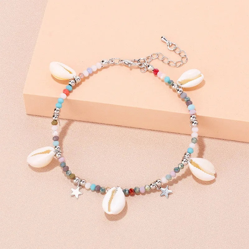 Bracelet de cheville "Brise Marine" orné de coquillages, perles colorées et petites étoiles argentées, style bohème chic.