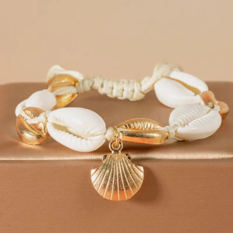 Bracelet de cheville "Protection Maritime" orné de véritables coquillages blancs et de perles dorées, avec un pendentif en forme de coquillage doré.