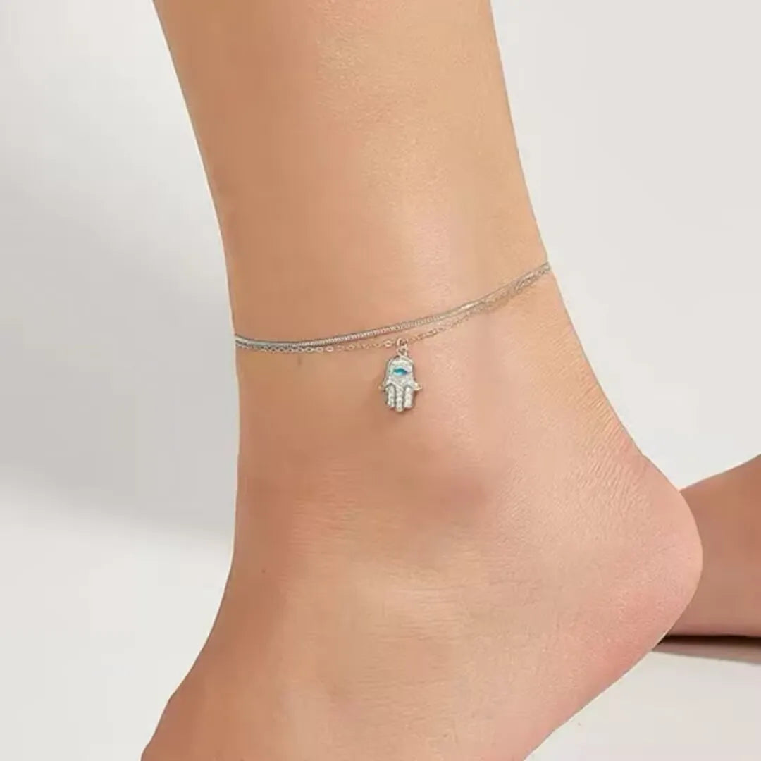 Bracelet de cheville double chaîne argent avec pendentif Main de Fatma orné d'un œil bleu et de zircons.