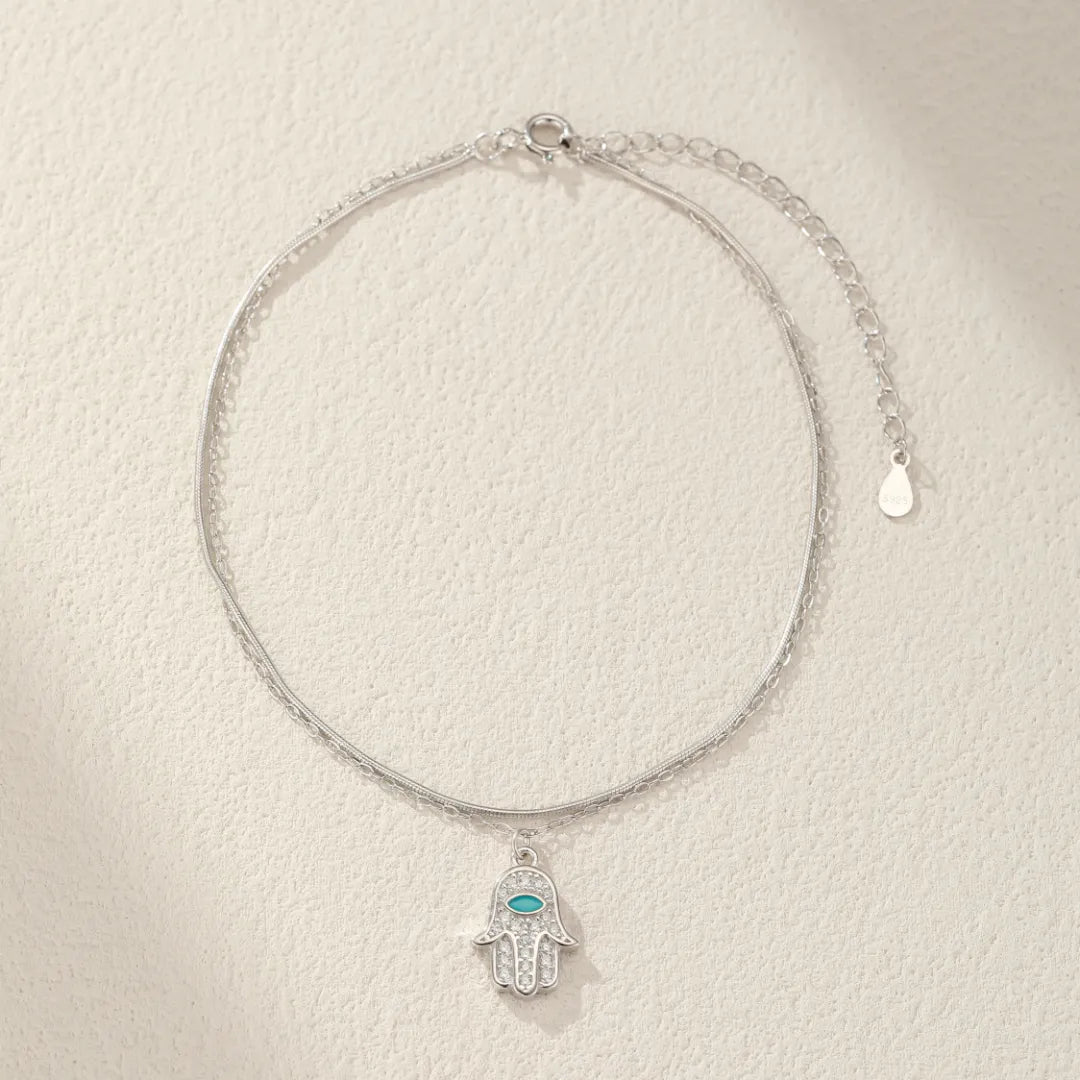Bracelet de cheville en argent 925 avec pendentif Main de Fatma orné de pierres scintillantes et d'une turquoise centrale.