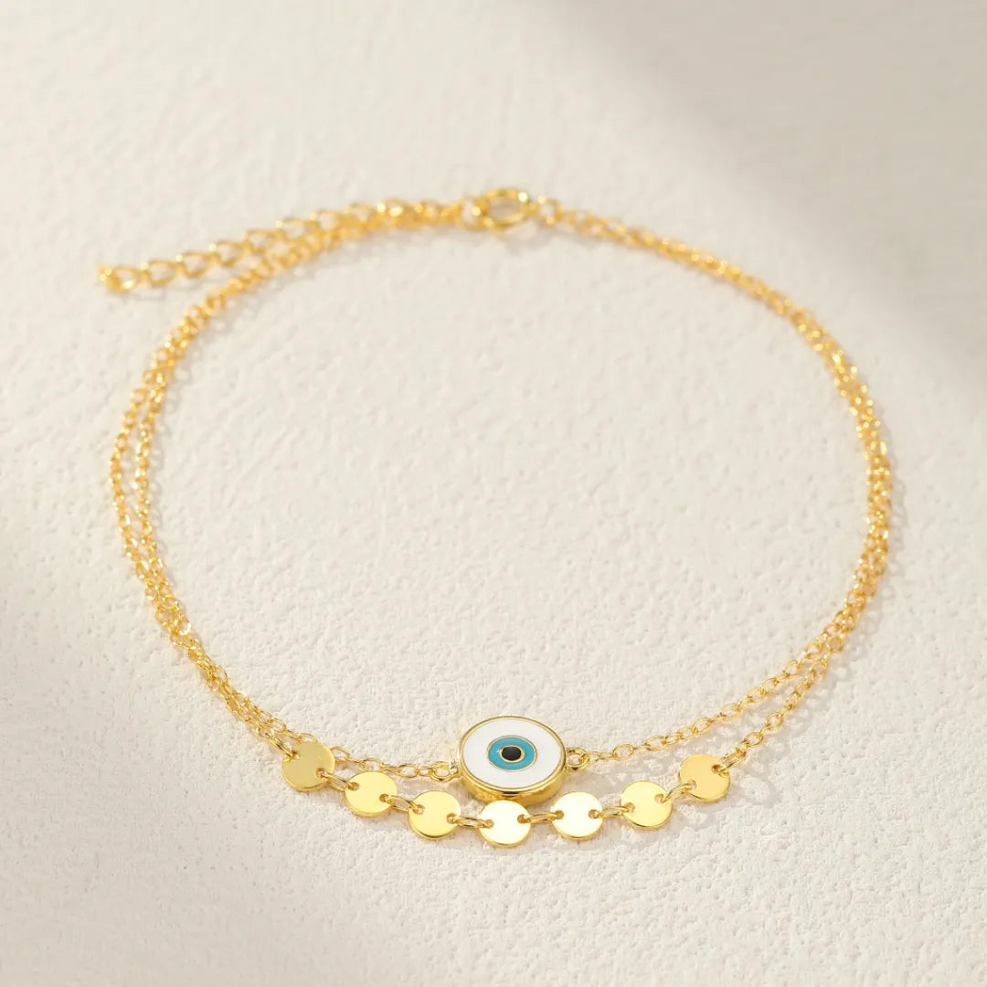 Bracelet de cheville double chaîne en argent avec un pendentif œil bleu et des disques dorés