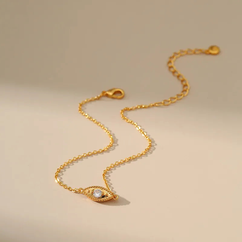 Bracelet de cheville "Talisman d'Antan" doré avec un pendentif œil serti d'une pierre blanche.