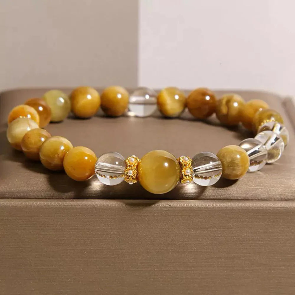 Bracelet en œil de tigre et cristal de roche avec des perles dorées texturées, symbolisant l'énergie vitale.