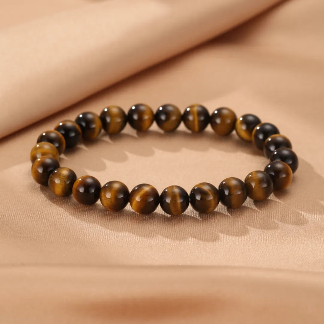 Bracelet en perles d'œil de tigre marron et doré, monté sur un fil élastique.