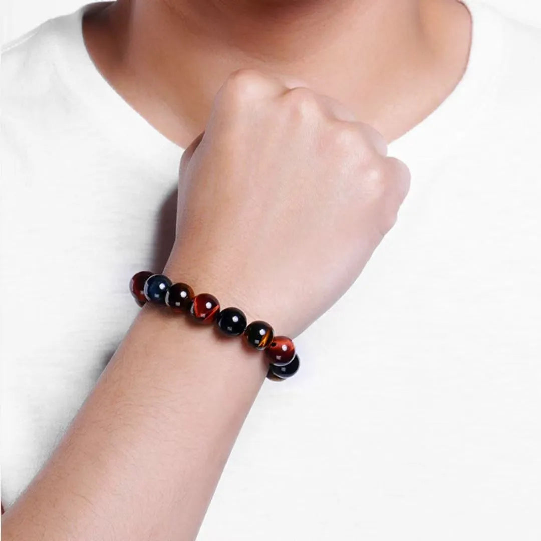 Bracelet "Reflets d'Équilibre" en œil de tigre multicolore porté au poignet d'une personne.