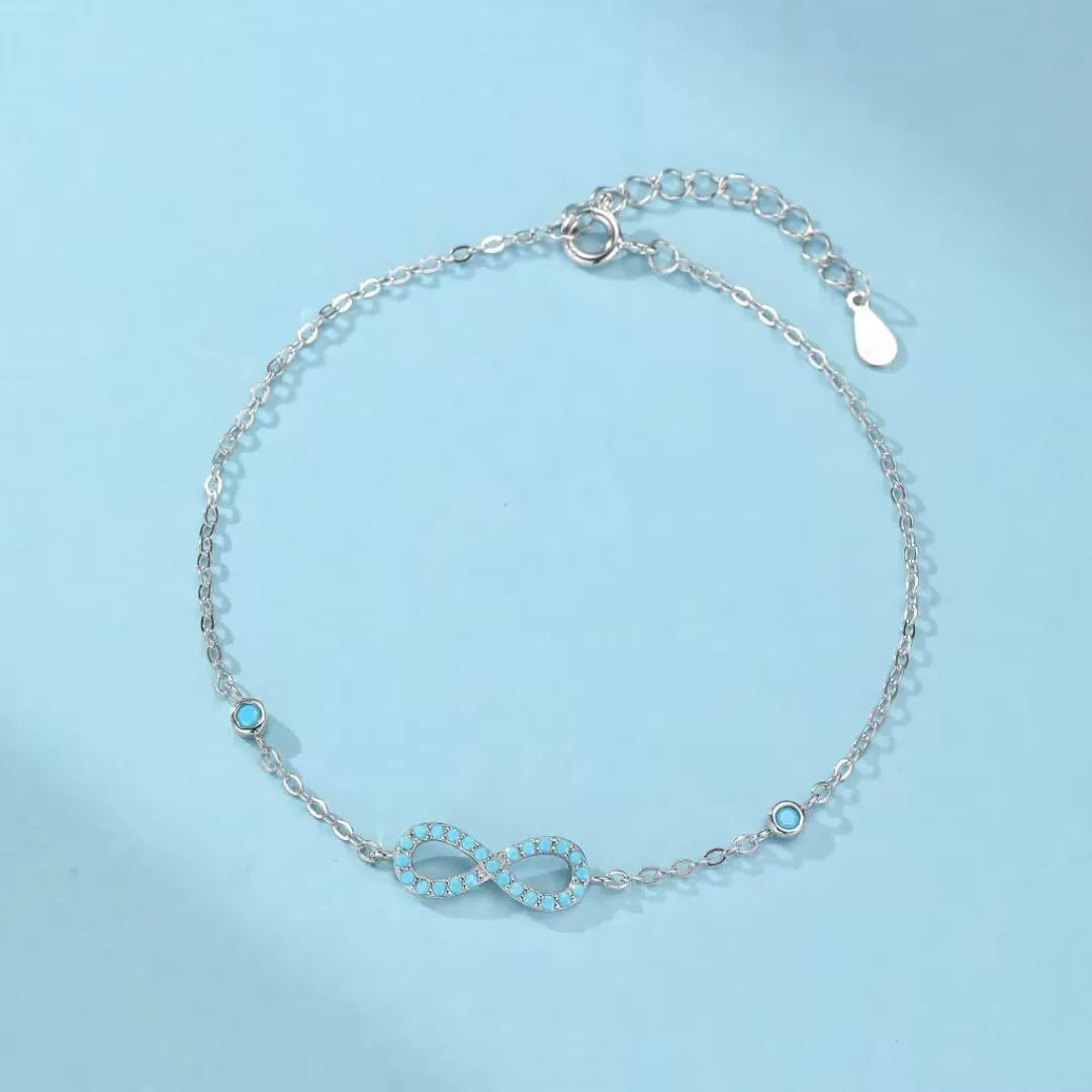 Bracelet Infini Turquoise "Souffle d'Infini" en argent 925 avec des petites pierres turquoise serties sur le symbole de l'infini.