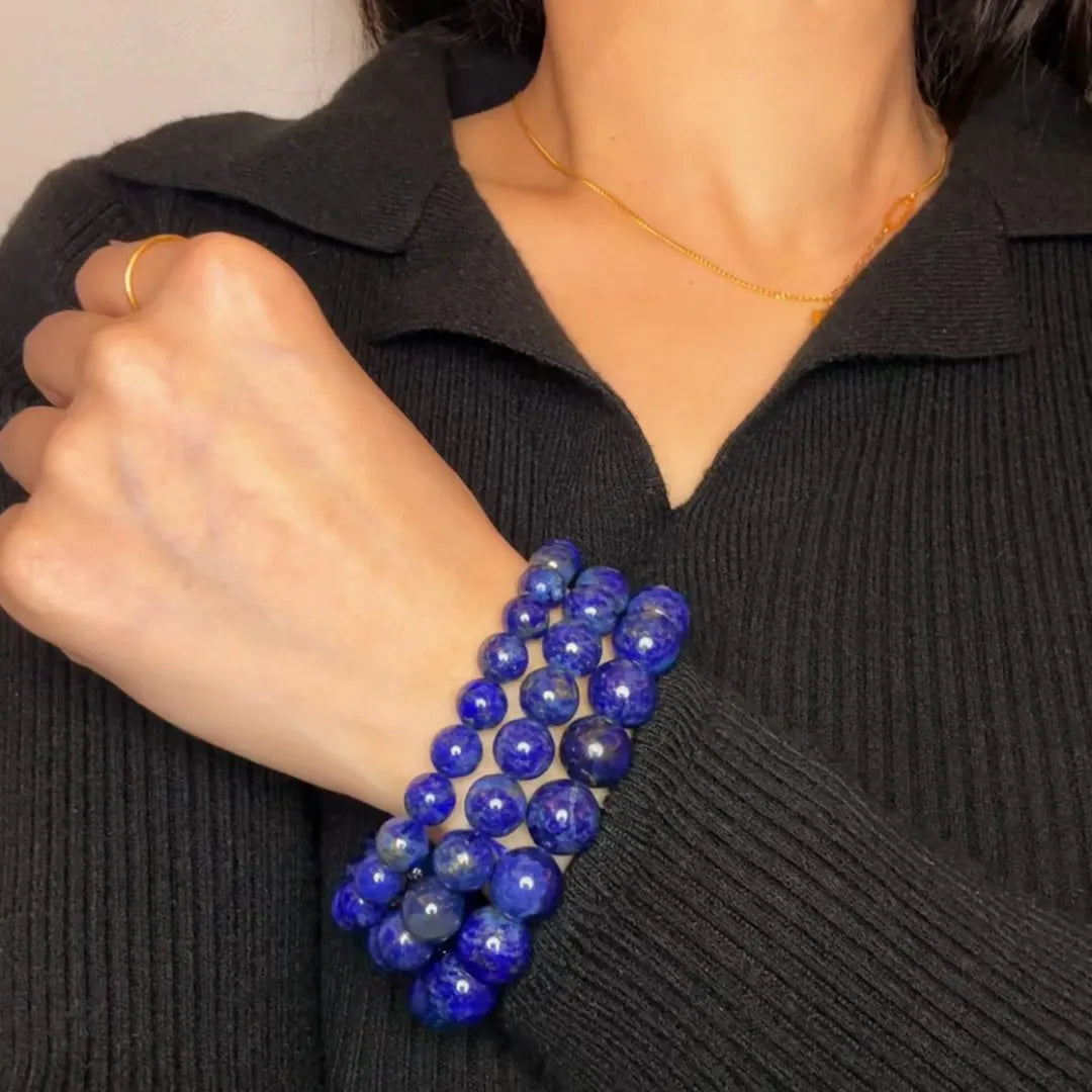 Bracelet en lapis-lazuli "Bleu Profond" composé de plusieurs rangées de perles bleues profondes de différentes tailles sur un poignet féminin.