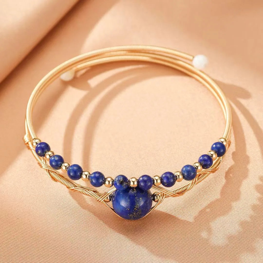 Bracelet jonc doré avec un grand cabochon bleu lapis lazuli et de petites perles bleues lapis lazuli, style bohème chic.