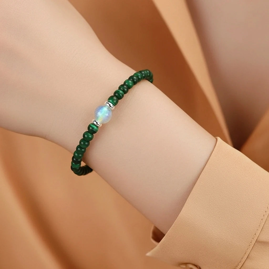 Bracelet "Transformation Intérieure" en malachite et labradorite, orné d'une perle centrale irisée et de perles argentées sur un poignet.
