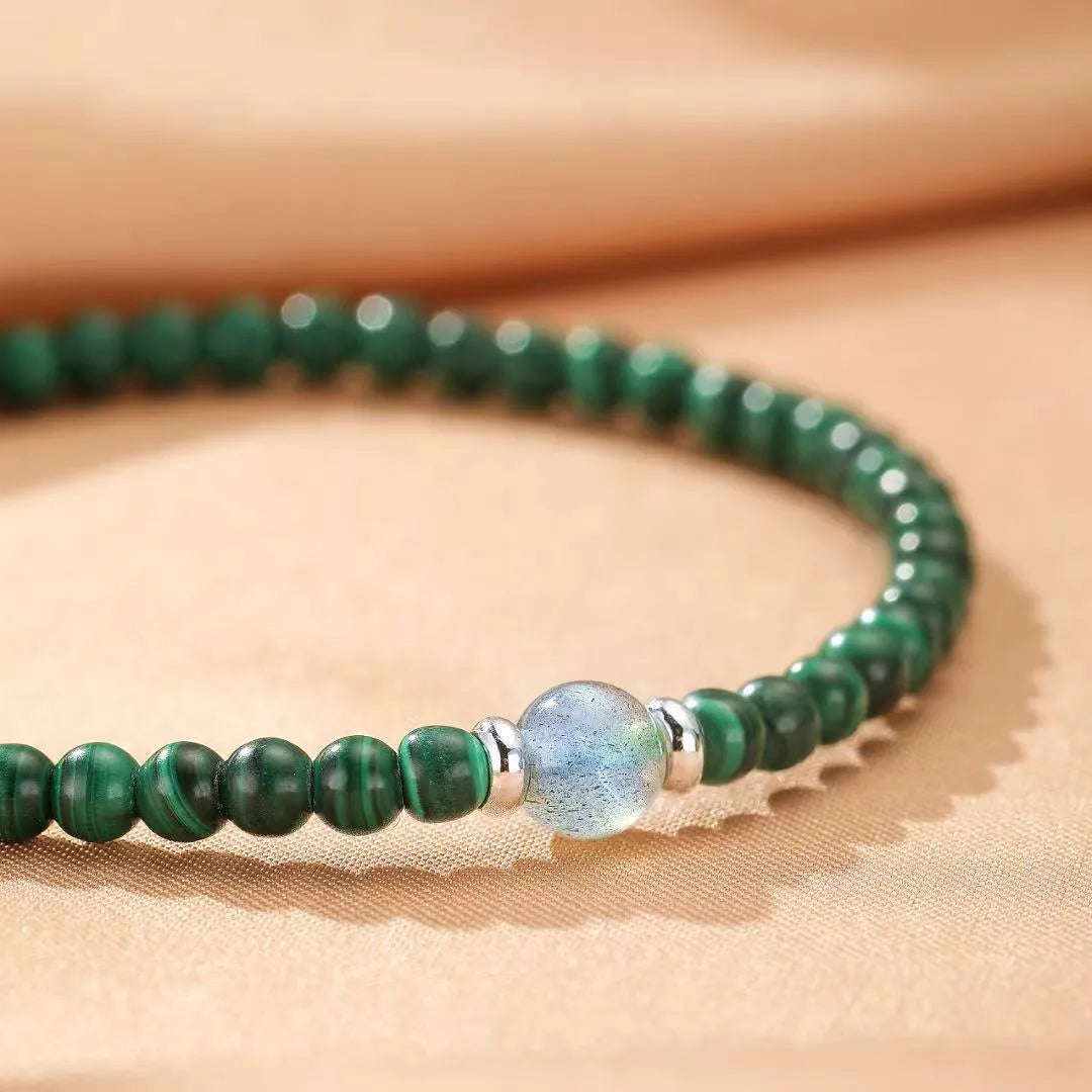 Bracelet en malachite et labradorite "Transformation Intérieure" avec des perles vertes et une perle bleue centrale, monté sur un fil argenté.