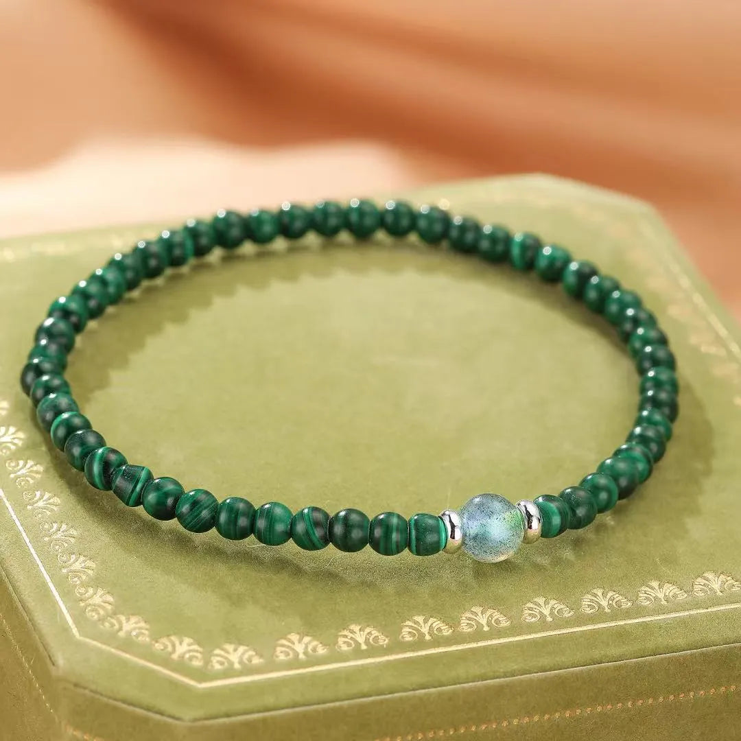 Bracelet "Transformation Intérieure" en malachite verte et labradorite bleue avec détails en argent, sur un écrin vert.
