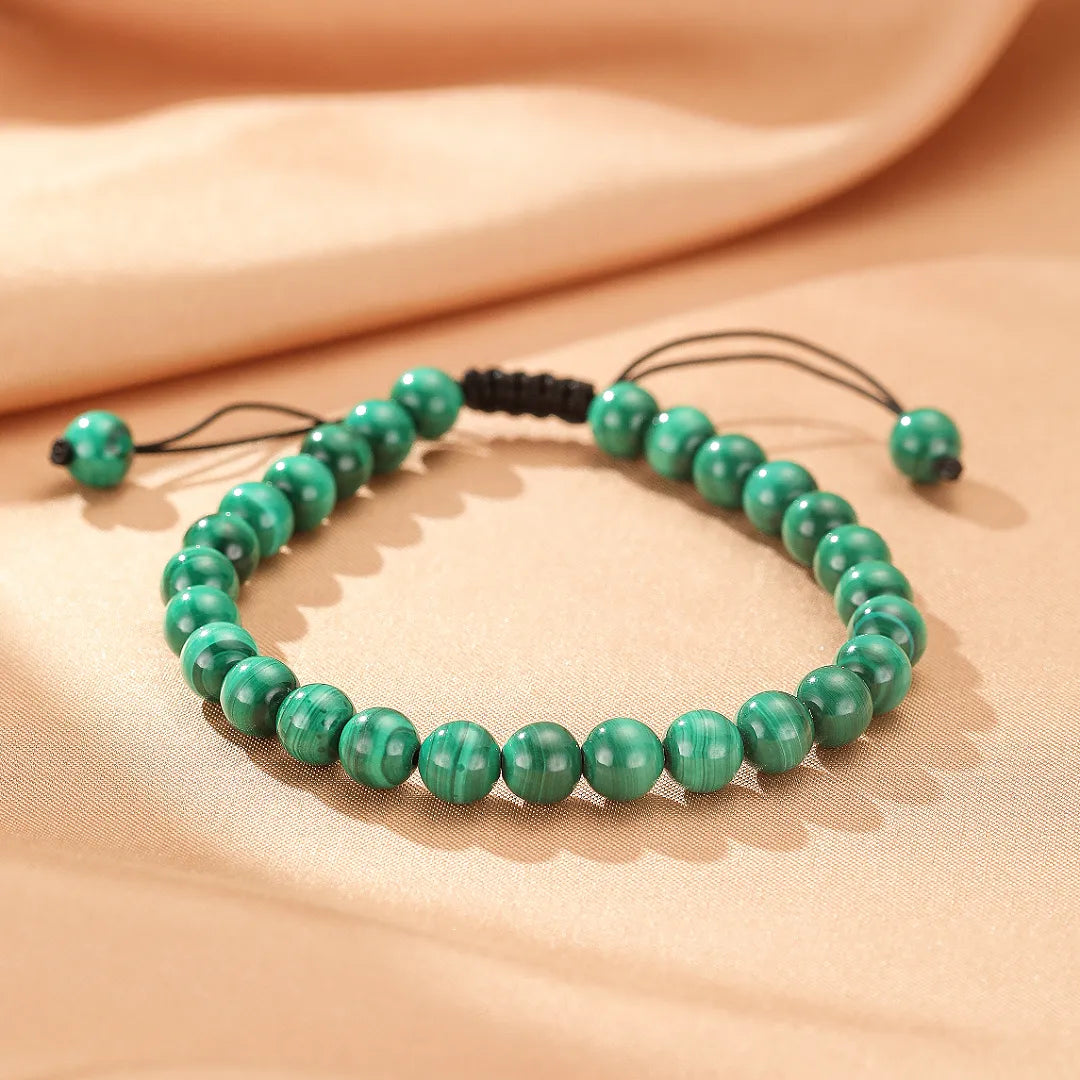 Bracelet "Harmonie Énergétique" en malachite avec des perles vertes et un cordon noir tressé, ajustable par un nœud coulissant.