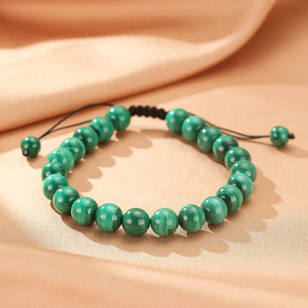 Bracelet "Harmonie Énergétique" fait de perles de malachite verte naturelle, avec un cordon ajustable noir.