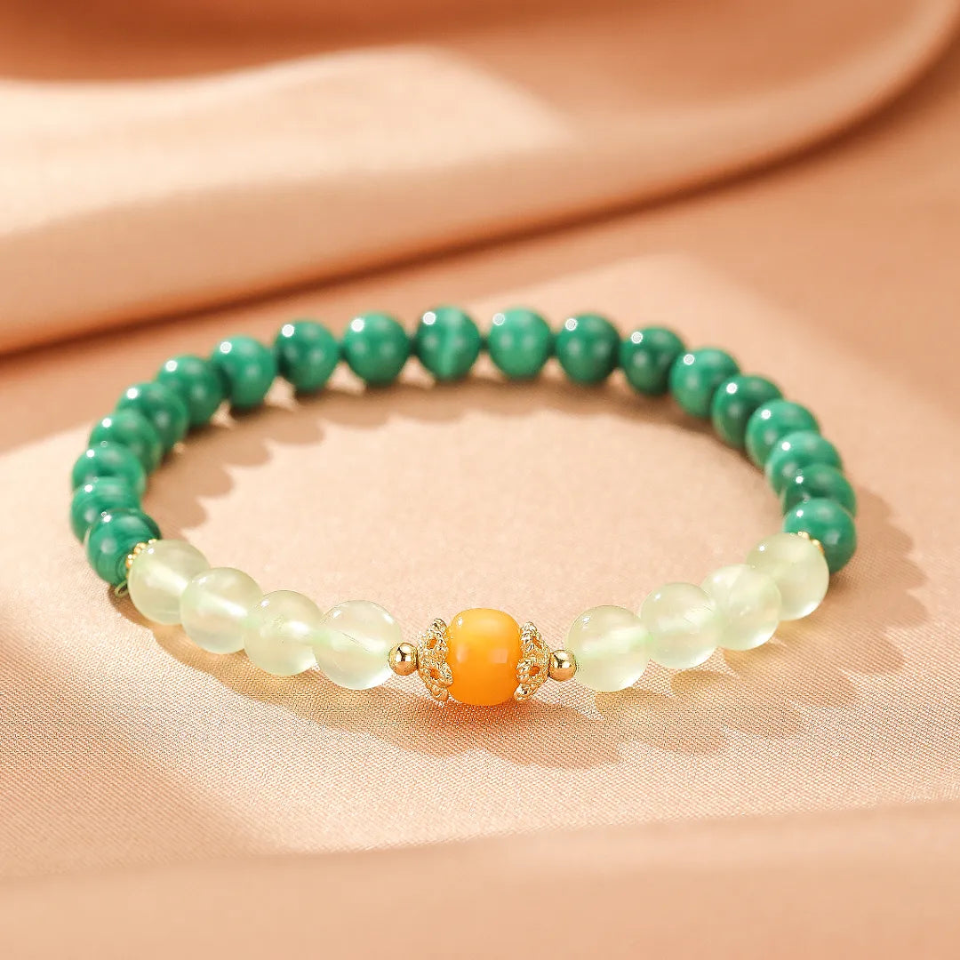 Bracelet "Harmonie Colorée" en pierres naturelles de Malachite, Préhnite et Ambre, avec des perles vertes et claires et un élément central orange orné de détails dorés.