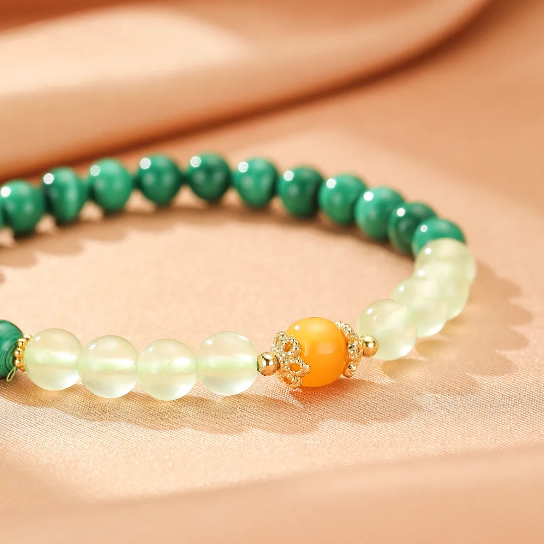 Bracelet "Harmonie Colorée" fait de perles de malachite verte, de préhnite pâle et d'ambre orangé, avec des détails dorés.