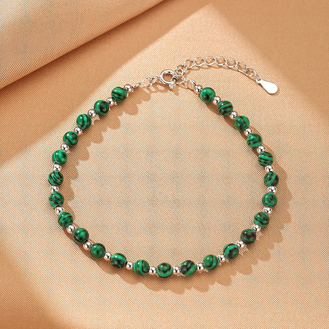 Bracelet "Veines d'Harmonie" en malachite et argent, avec des perles rondes vertes et noires alternant avec de petites perles argentées, fermoir mousqueton.