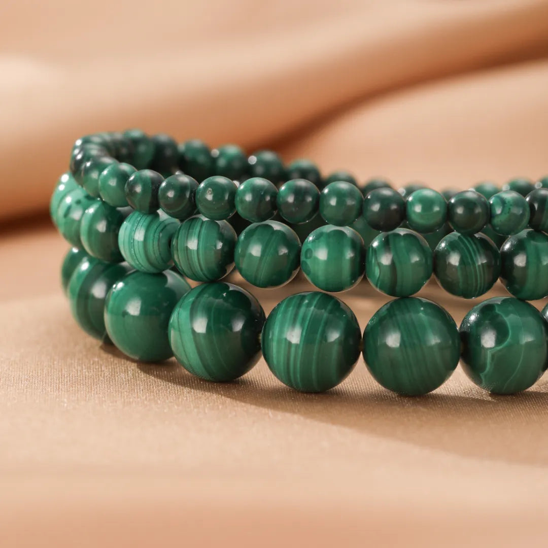 Bracelet "Veines Vertes" en malachite, composé de perles rondes vertes foncées et claires avec des motifs veinés caractéristiques.