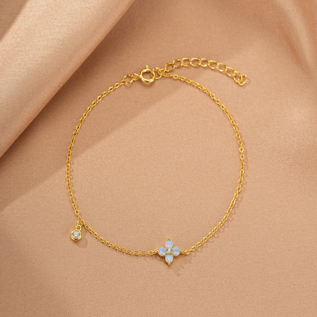 Bracelet "Fleur Pure" en argent doré or, orné d'une petite fleur en opale bleue et d'un cristal.