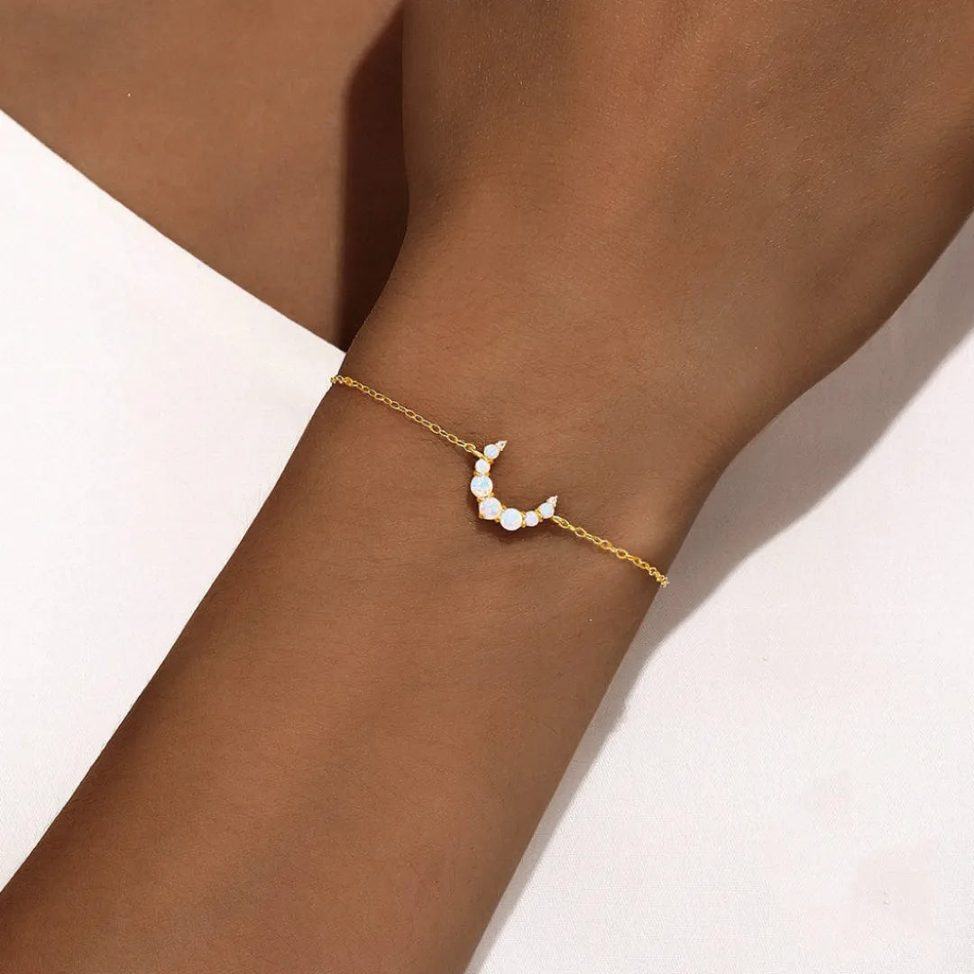 Bracelet fin en argent doré or 18 carats avec un motif croissant de lune serti d'opales et de petits cristaux.