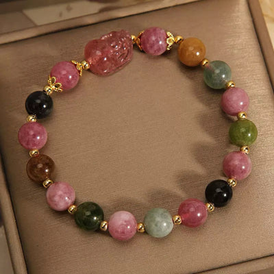 Bracelet "Richesse Spirituelle" en Tourmaline et Quartz Fraise avec une figurine Pi Xiu sculptée, orné de perles multicolores et de détails dorés.