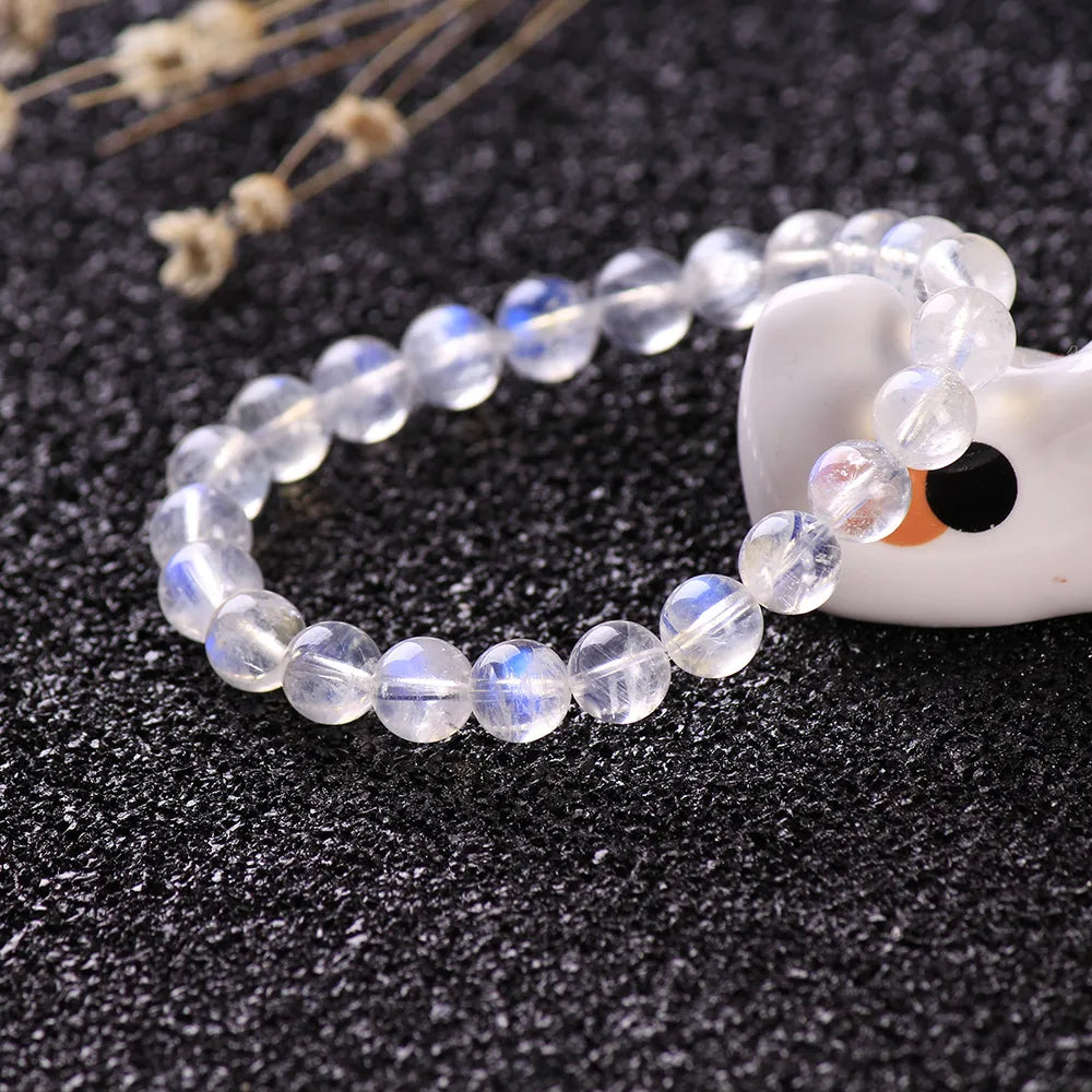 Bracelet "Rêve Doux" en pierre de lune aux reflets bleutés et nacrés, composé de perles rondes facettées.