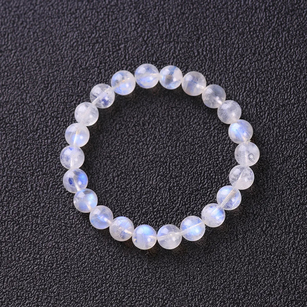 Bracelet en pierres de lune naturelles "Rêve Doux" montées sur élastique, sur fond noir.