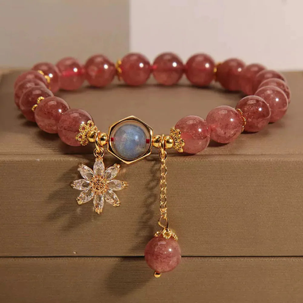 Bracelet "Fleur Mystérieuse" en quartz fraise et cristal de roche avec breloque fleur en zircon et pierre centrale hexagonale.