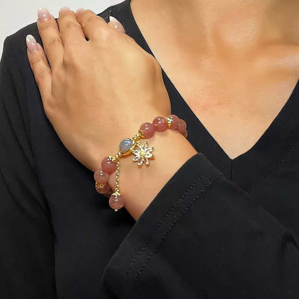 Bracelet en quartz fraise et cristal de roche avec un pendentif en forme de fleur ornée de petites billes.