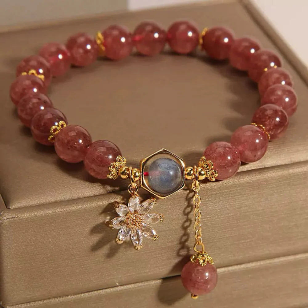 Bracelet en quartz fraise et cristal de roche avec pendentifs fleur et pierre hexagonale.