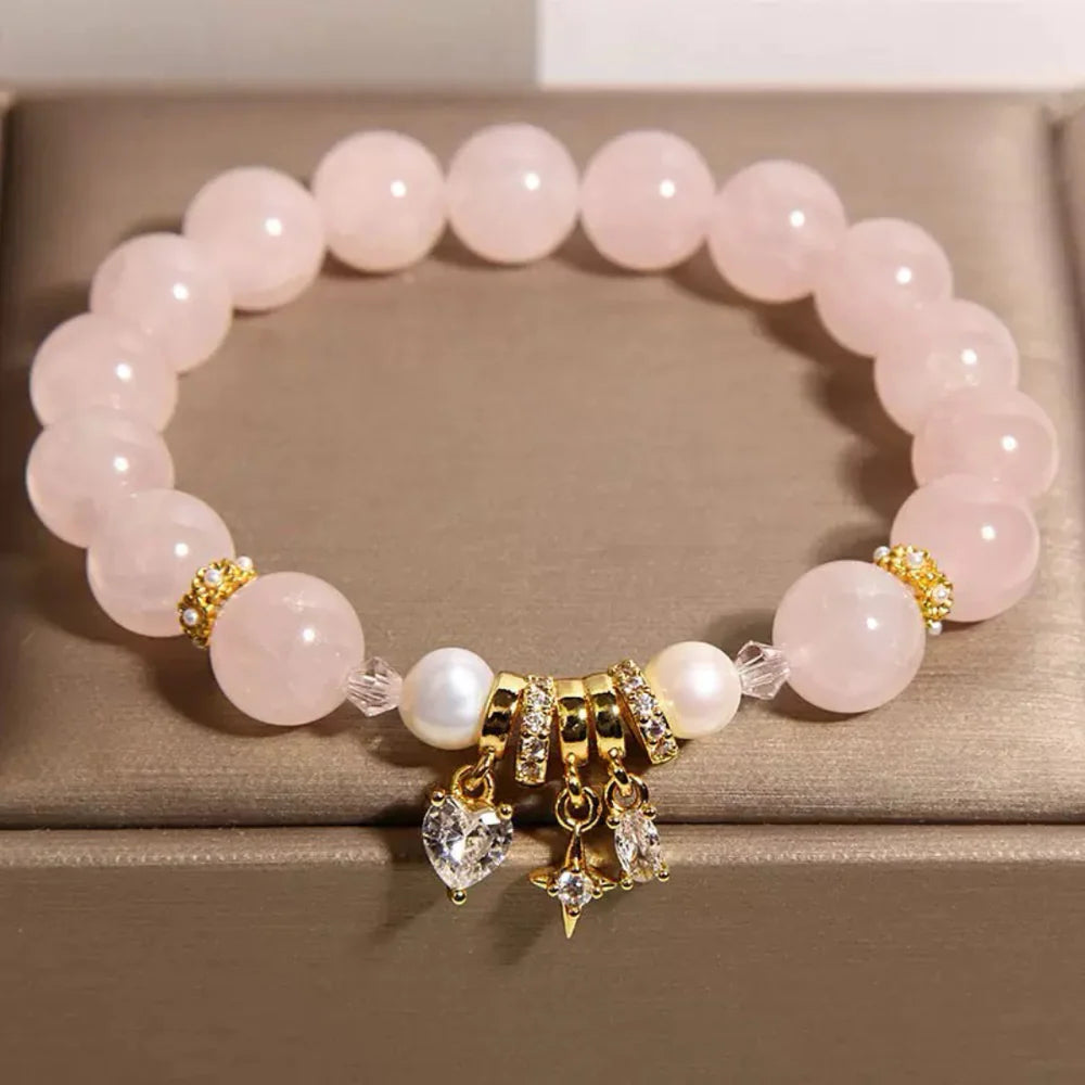 Bracelet "Douceur Céleste" en quartz rose, perles blanches et breloques cœur, étoile et croissant de lune en or et zircons.