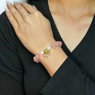 Bracelet "Douceur Céleste" en quartz rose et perles, orné d'un pendentif doré.